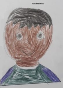 Desenho do rosto de um garoto pintado com lápis de cor. A pele é marrom, o cabelo é preto e ele usa uma camiseta azul.