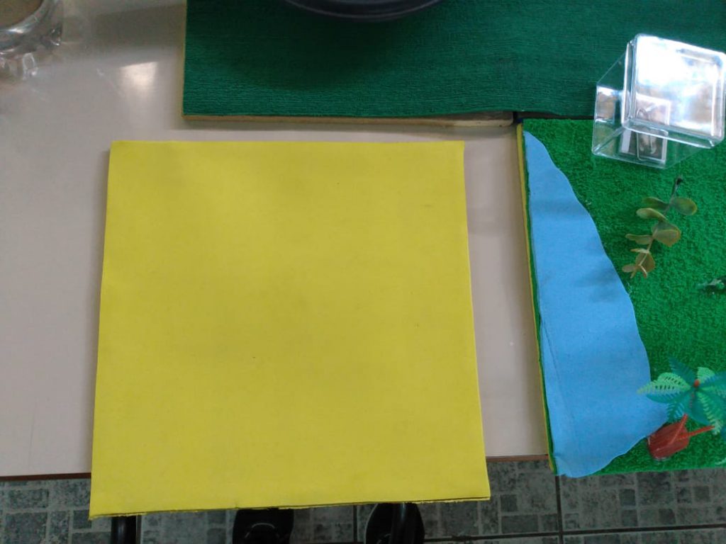 Parede quadrada amarela é encaixada em lateral do tabuleiro. Fim da descrição.