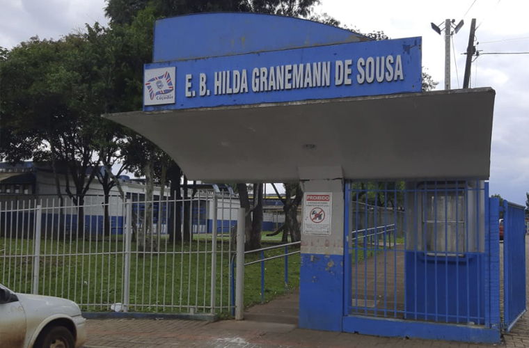 Imagem da frente da Escola Hilda Granemann de Sousa, no qual há um letreiro com nome da unidade. Fim da descrição. 