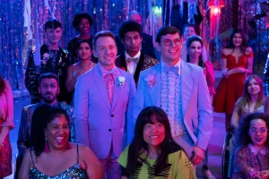 Cena da série Special mostra um grupo diverso de pessoas sorridentes em um baile de formatura ou festa festiva, iluminado por luzes roxas e azuis. A produção é uma das 13 séries com pessoas com deficiência indicadas por especialistas no texto.